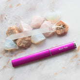 Nail Tek Medium 5 inch Crystal File on top decorative stones side by side with Fuschia case all laid on marble background