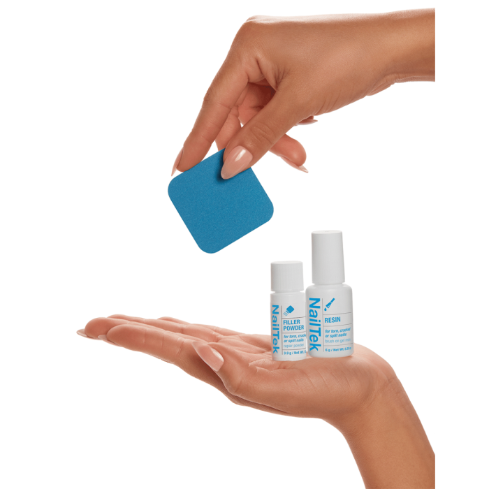 NailTek Nail Repair System components, including resin, filler powder, and a buffer, displayed in hand for scale.